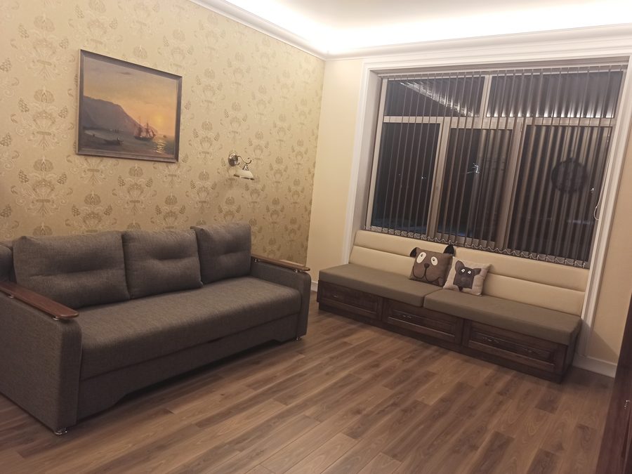 Завершённая гостиная с декоративной отделкой стен и скрытой потолочной подсветкой.